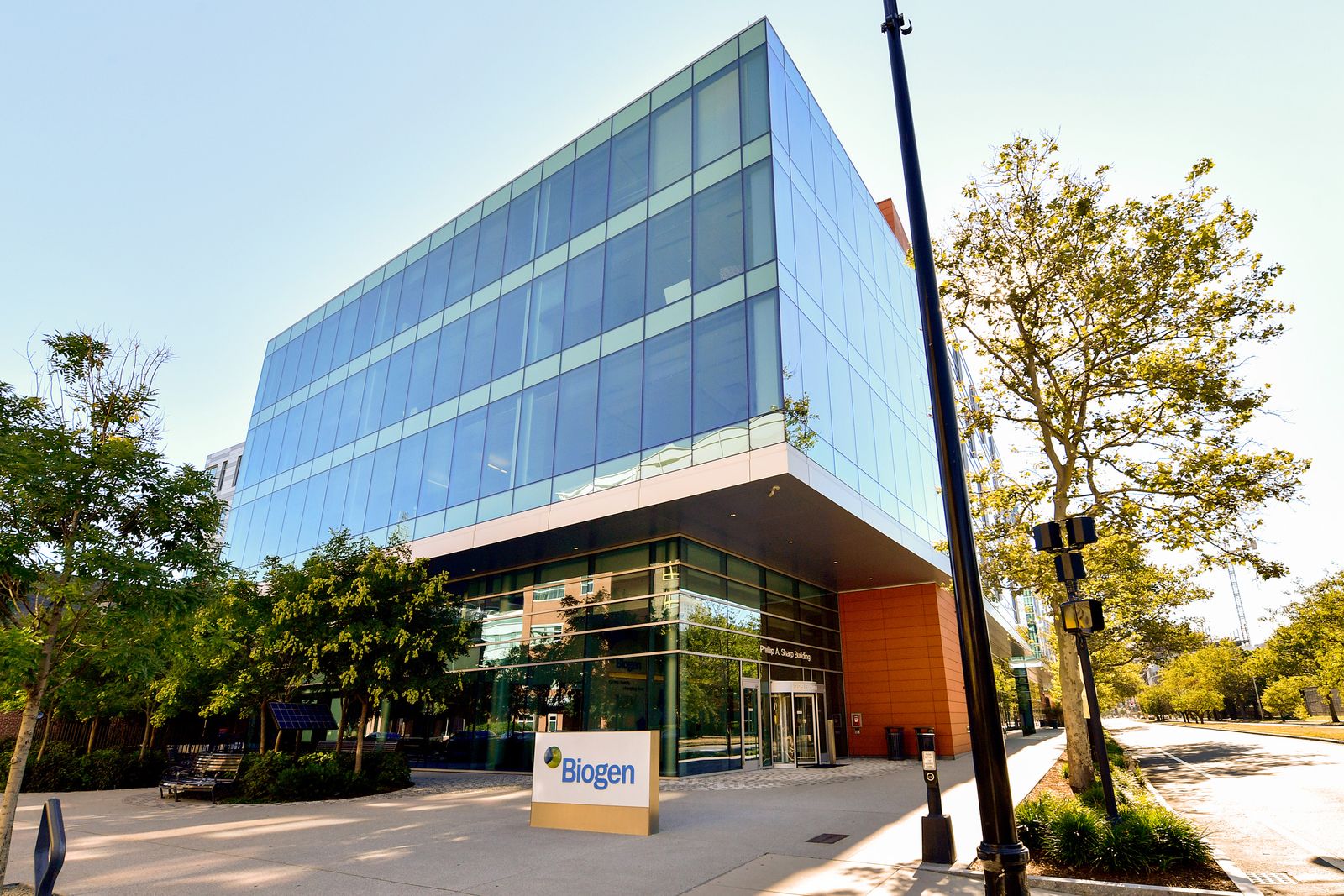 A glass building with a sign that reads, "Biogen."